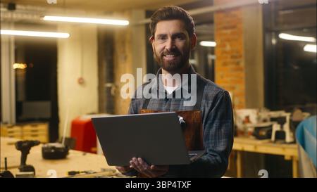 Positive Caucasian wood master man typing laptop online in workshop small business craftsman guy using computer device male joiner worker smile Stock Photo