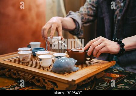 Tea master preparing tea set for ceremony, closeup hands, tea house Stock Photo