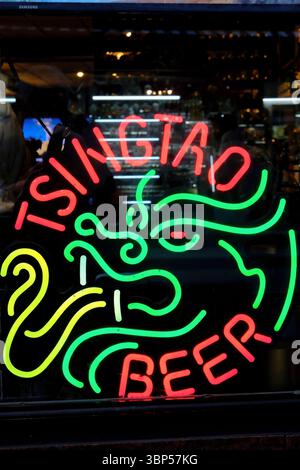 The neon signs of Tsingtao Beer in Chinese on the window of a Chinese restaurant in Chinatown.Manhattan.New York City.USA Stock Photo