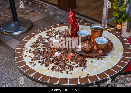 A Bosnian coffee set (kahveni takum) with copper cezve and cups on a table in old town of Sarajevo Stock Photo