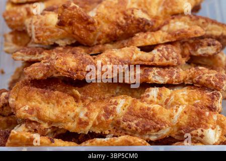 Crispy brown cheese straws at a food market. Stock Photo