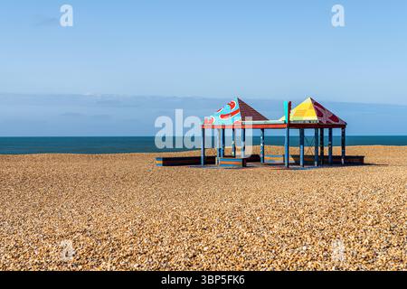 Folkestone, Kent, England - May 08, 2022: A pavilion on Folkestone beach, with the Channel coast in the background Stock Photo