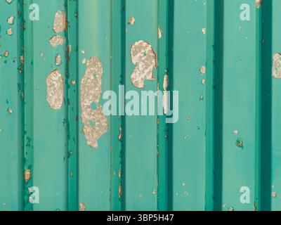 Peeling turquoise paint on metal wall Stock Photo
