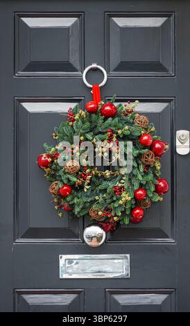 Decorative Christmas wreath hangs on a front door of a house in Kensington, London, England, United Kingdom, UK Stock Photo