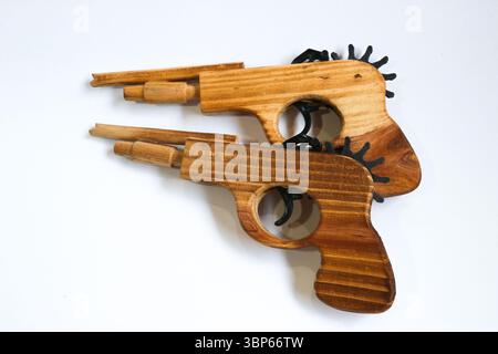Vintage toy Two handmade wooden toy guns placed side by side on white background. Rustic texture and craft style. Stock Photo