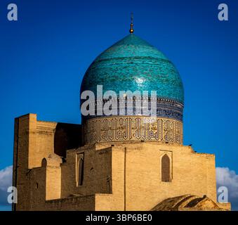 A stunning view of a historical building featuring a large turquoise dome and intricate tile work, set against a bright blue sky with fluffy clouds. Stock Photo