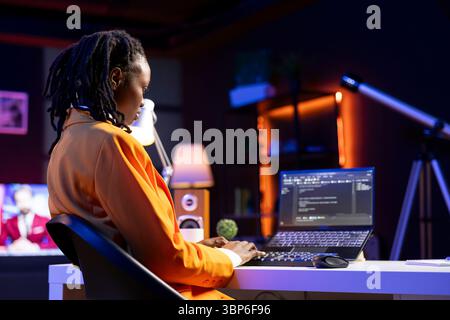 Freelancing admin in home office using laptop to write programming language code. Young software technician working from apartment using notebook device to build application Stock Photo