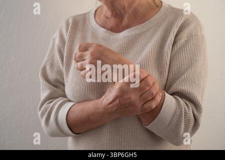 Elderly European Woman Suffering from Joint Pain, for Example in the Elbow Stock Photo