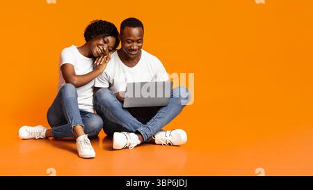 Carefree african american couple using laptop together Stock Photo - Alamy