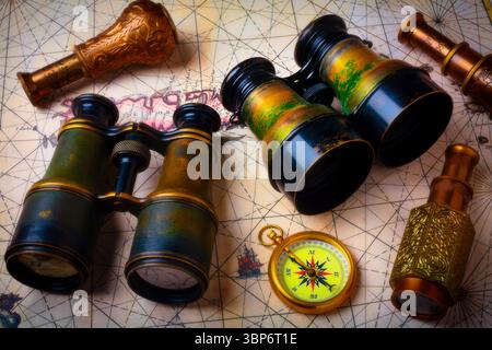 Binoculars And Telescopes With Compas On Old Map Stock Photo