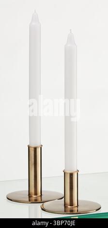 Two candles placed on gold colored metal legs isolated nature background with clipping path Stock Photo