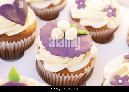 Closeup photo of colorful cupcakes with sugar icing in paper box Stock Photo