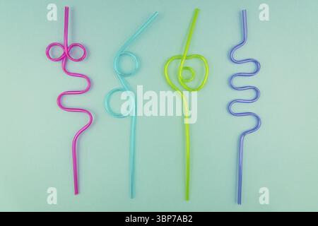 Multicolored plastic cocktails straws on blue background Stock Photo