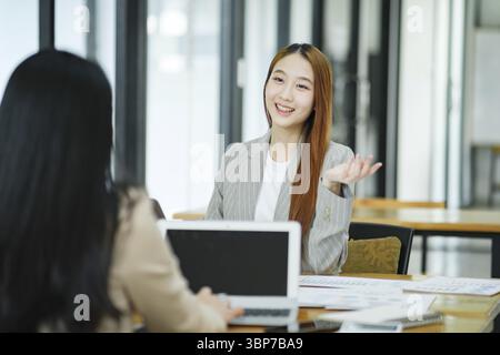 Two business professionals engaged in a serious discussion, possibly conducting a job interview in a modern office environment Stock Photo