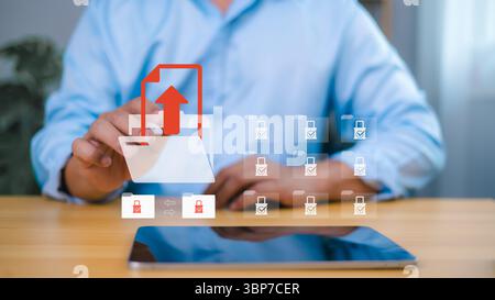 Businessman uploading secure files using digital folder icon on virtual screen, data protection and cloud storage technology concept. Stock Photo
