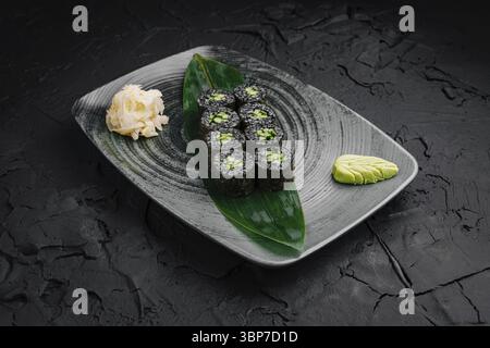 Food, Delicious sushi rolls filled with fresh ingredients are elegantly arranged on a decorative plate. Wasabi and pickled ginger accompany the dish, Stock Photo