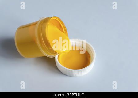 Demonstrating trendy colors 2021 - Gray and Yellow. Open can with yellow gouache paint Stock Photo