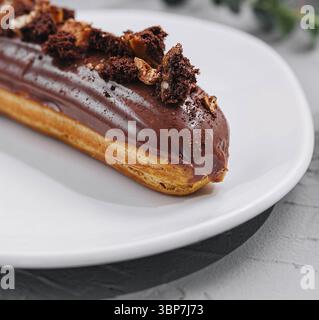 Food, Eclair with Chocolate Cream and Hazelnuts closeup Stock Photo