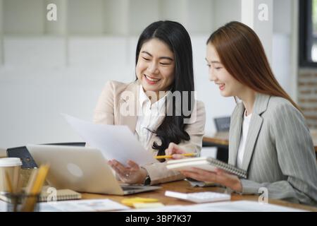 Working women are discussing work and planning new business plans exchanging ideas with colleagues Stock Photo