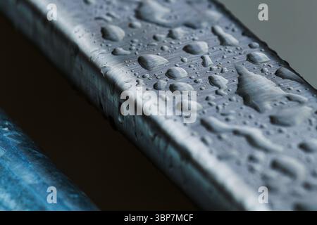 Raindrops on smooth metallic industrial object surface, weather and climate concept, selective focus Stock Photo
