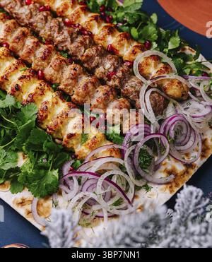 Food, Colorful arrangement of grilled kebabs served on a festive table with seasonal decorations Stock Photo