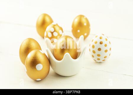 Easter festive decoration.Close up of easter eggs colored with golden paint on wooden background. Various dotted designs Stock Photo