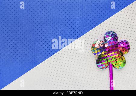 Flower made of sequins on double white and blue star background background. Minimal flat lay, copy space Stock Photo
