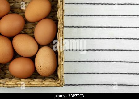 Zero waste easter background. No plastic concept. Minimal style. Beige water hyacinth box with brown chicken eggs on textile background Stock Photo