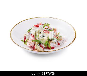 Food, Salad with sour cream sauce seasoned with red hot chili pepper and decorated with green onion served on white plate Stock Photo