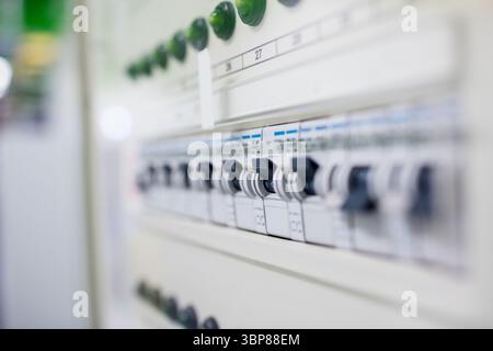 Flat design circuit breaker panel is showcasing toggle switches with printed labels and green knobs Stock Photo