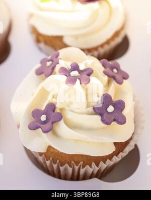 Closeup photo of colorful cupcakes with sugar icing in paper box Stock Photo