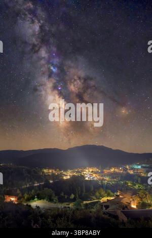 Laspaúles town seen from Suils viewpoint at night, with the lights of the town and the milky way over it. Stock Photo