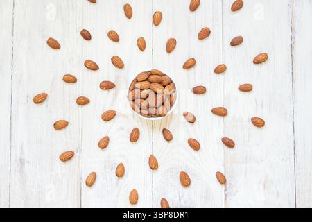 Roasted Almonds in white porcelain bowl on white wooden table Stock Photo