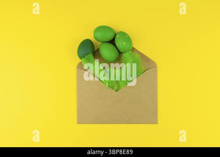 Spring Easter layout with green feathers and eggs, craft envelope on yellow background. Copy space for text for text Stock Photo