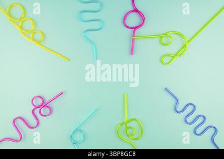 Multicolored plastic cocktails straws on blue background Stock Photo
