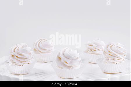Food, Five gourmet cupcakes with pink and white icing on a classic white cake stand against a seamless background Stock Photo
