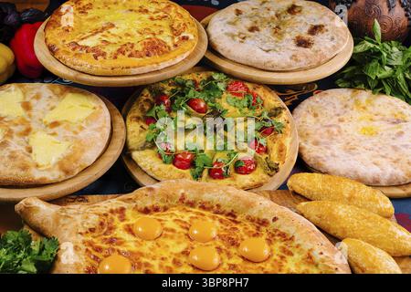 Food, Khachapuri, a traditional georgian dish of cheese-filled bread, is served on wooden plates in a restaurant setting Stock Photo