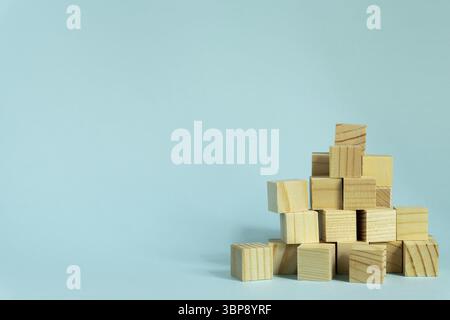 Construction of wooden cubes on blue background with copy space. Mockup composition for design Stock Photo