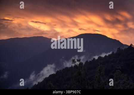 Mammatus clouds glow at sunset, enchanting the Alt Urgell mountains with a magical light, Catalonia Stock Photo