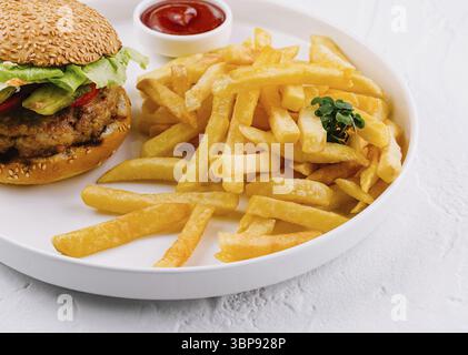 Food, Juicy hamburger paired with golden fries and a dollop of ketchup on a clean white background Stock Photo