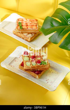 belgian waffle with strawberries on yellow background Stock Photo