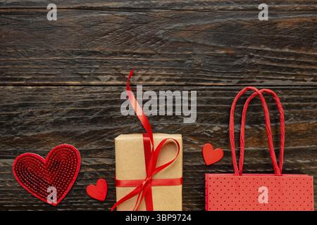 Paper craft Gift box with red ribbon bow, paper bag and red hearts. Festive concept for Valentine's day, Mother's day or birthday Stock Photo