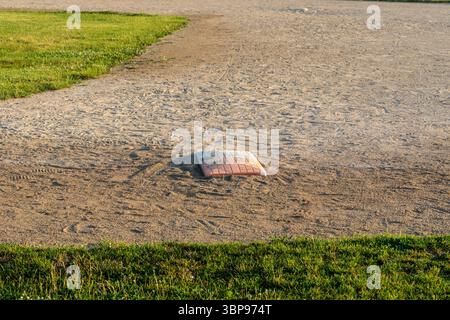 close up of first base on diamond two in the park at dawn Stock Photo