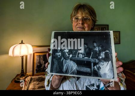 Eva Eberwein, co-owner and curator of the Mia and Hermann Hesse House in Gaienhofen, displays a photograph of Mia Hesse showing an unposed scene of pupils at a girls' school. Almost all of the people pictured are engaged in an activity. Hermann-Hesse-Weg, Gaienhofen, Baden-Württemberg, Germany Stock Photo