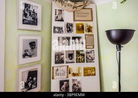 A display board with numerous photographs of Mia Hesse's three sons hangs in the Mia and Hermann Hesse House in Gaienhofen, Baden-Württemberg, Germany, beside framed family photographs, including one of a mother holding a baby. Mia Hesse was Switzerland's first professional female photographer and ran a photo studio in Basel from 1903. The photographs on display document the family's country life with Hermann Hesse on the Höri peninsula. Stock Photo