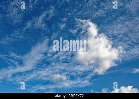 White wispy cloud formation against a blue sunny sky Stock Photo