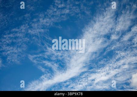 White wispy cloud formation against a blue sunny sky Stock Photo