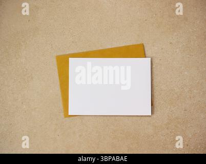 Blank white card and yellow envelope on beige speckled background, minimal stationery mockup template for invitation, greeting or message design Stock Photo
