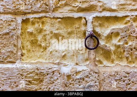 Close-Up of a Stone Wall With a Metal Ring Attached Stock Photo