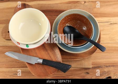 Ceramic Bowl, Plate, Wooden Plate, Knife, Spoon, and other Kitchen Equipment on Wooden Table Stock Photo